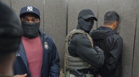 Immigration and Customs Enforcement agents escort a detained immigrant into an elevator after he exited an immigration courtroom.