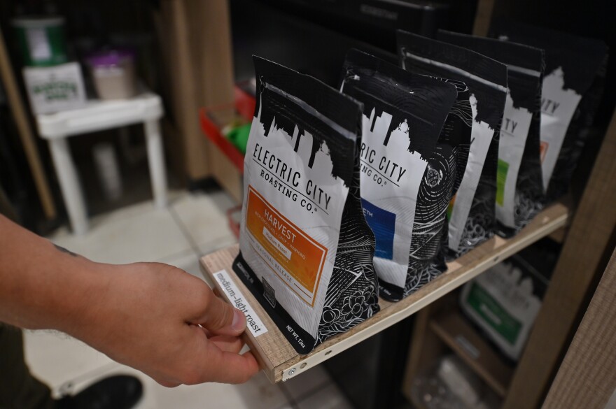 Kyle Mervau pulls out some of the types of coffee available at Electric City Roasting Co.