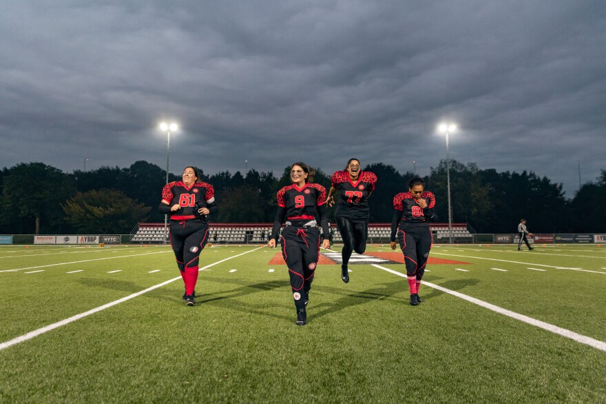 <strong>Left to right:</strong> Amsterdam Cats center Michelle Pouw, quarterback Kelly de Waard, center guard Sitara Sheomber and defensive back Rufina Michels-Mastail walk back to the rest of the team after winning the coin toss before the first and only game of the 2020-2021 season against the Rotterdam Ravens in Amsterdam,  Netherlands, on Sept. 27, 2020.