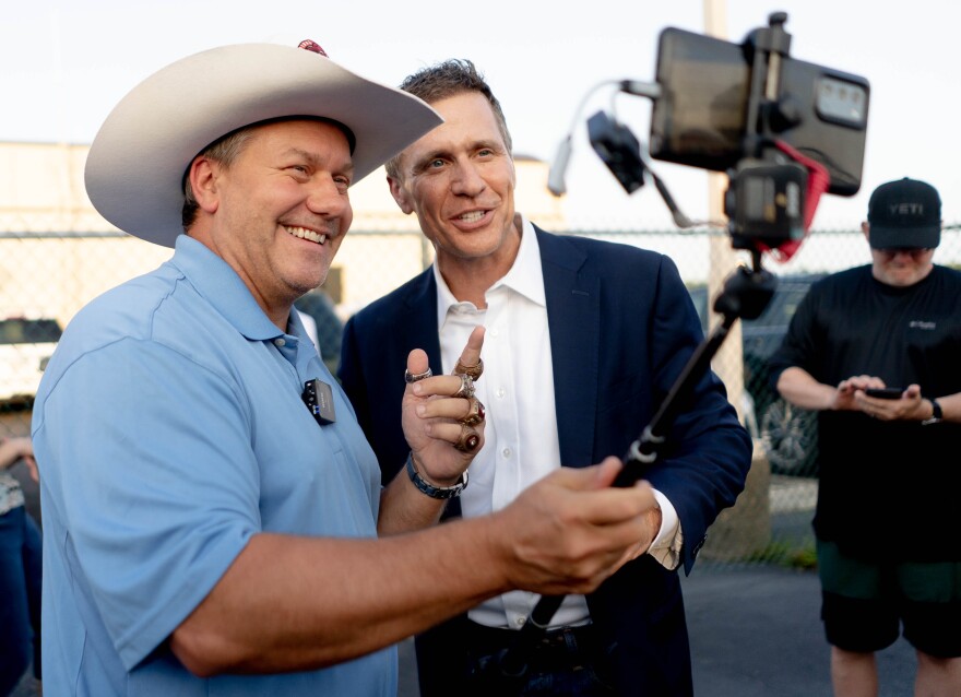 Carter Rethwisch, the "Cardinal Cowboy" of St. Charles, records a video with Eric Greitens, former Missouri Governor and U.S. Senate-hopeful, on Monday, Aug. 1, 2022, during a campaign stop at the Spirit of St. Louis Airport in Chesterfield.