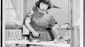 Caption by photographer Dorothea Lange: Ester Naite, an office worker from Los Angeles, operates an electric iron in her quarters at Manzanar, California, a War Relocation Authority center where evacuees of Japanese ancestry will spend the duration. 