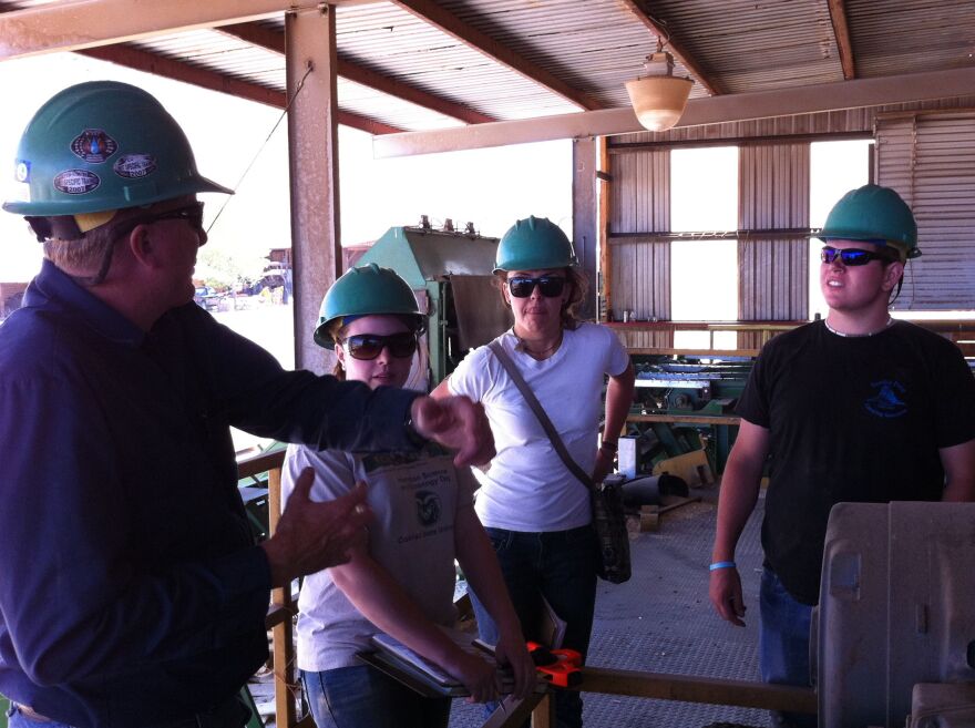 Michael Kostrzewa, senior research associate in mechanical engineering talking with students about sawmill operations during an assessment to a lumber company in Saguache.