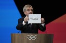 IOC president Thomas Bach holds the board Salt Lake City during the 142nd IOC session at the 2024 Summer Olympics, Wednesday, July 24, 2024, in Paris, France. Salt Lake City was confirmed as host for the 2034 Winter Games by International Olympic Committee.