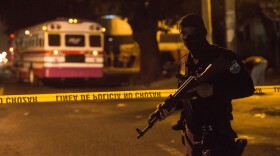 A police officer stands guard after the murder of a bus driver in San Salvador.