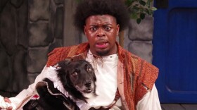 A man appears surprised and concerned as his dog sits looking longfully away from him. 