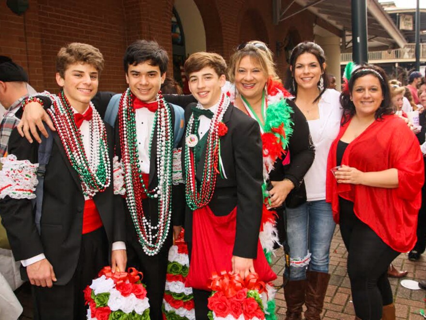 As they travel the parade route, tuxedoed men and youths distribute strings of colorful beads, dried fava beans and genuine Italian kisses.