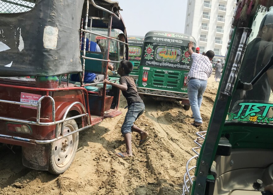 Motorized rickshaws get stuck in the sand on the beach in Cox's Bazar, Bangladesh. All traffic heading south out of town was diverted on to the beach when the main road was closed for repairs.