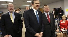 In this May 1, 2018, file photo, from left, Senate leader Phil Berger, North Carolina Gov. Roy Cooper and House Speaker Tim Moore pause prior to a news conference in Raleigh, N.C.