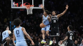 Memphis Grizzlies' Ja Morant (12) spins around Brooklyn Nets' Nic Claxton (33) during the first half of an NBA basketball game, Monday, Nov. 4, 2024, in New York. (AP Photo/Seth Wenig)