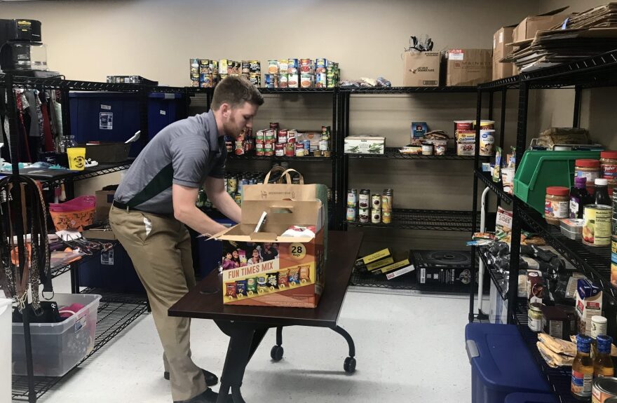 Michael Payne sorts through boxes of donated food at the end of the 2019 school year at Northeastern State University.