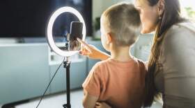A mother livestreams with her child. (Getty Images)