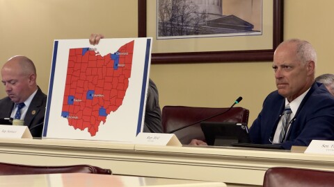 Reps. Brian Stewart (R-Ashville), left, and Adam Bird (R-New Richmond), right, sit in the Joint Committee on Congressional Redistricting, as Nick Santucci (R-Niles) holds a map of counties President Trump won in 2024.