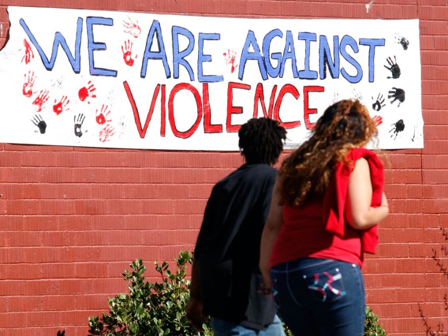 Students walk past a sign protesting violence near Richmond High School in Richmond, Calif. Some students say they are upset about how the school is being portrayed in the media.
