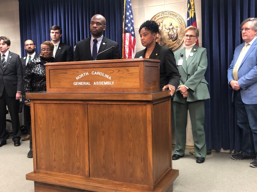 Rep. Allen Buansi (D-Orange), left, and Sen. Kandie Smith (D-Edgecombe, Pitt), backed by fellow Democrats, on March 8, 2023, addressing reporters about newly filed legislation aimed at clamping down on voter intimidation, providing for online voter registration, and establishing a non-partisan redistricting process.