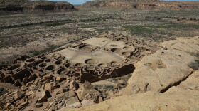 FILE - A hiker sits on a ledge above Pueblo Bonito, the largest archeological site at the Chaco Culture National Historical Park, in northwestern New Mexico, on Aug. 28, 2021. The Biden administration is implementing a 20-year withdrawal banning oil and gas development outside the boundaries of Chaco Culture National Historical Park in northwestern New Mexico. The action taken by Secretary of the Interior Deb Haaland in the nation’s No. 2 oil-producing state was announced Friday June 2, 2023. (AP Photo/Cedar Attanasio, File)