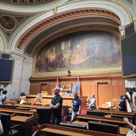 Tourists of the Wisconsin Legislature walk through the Assembly chamber where state laws are passed.