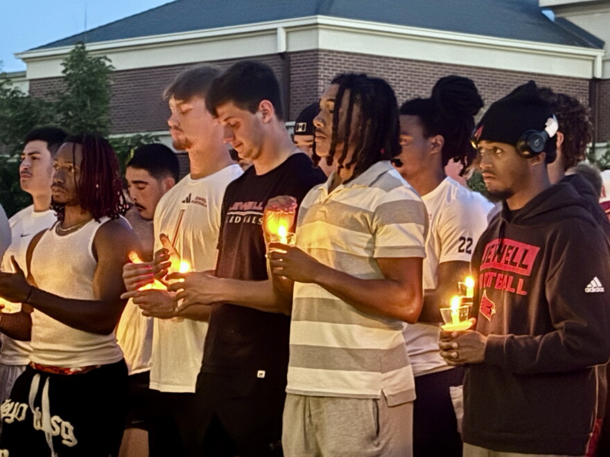 MicahJo Barnett's teammates hold candles Saturday night during the vigil following his death during William Jewell College's first football game of the season.