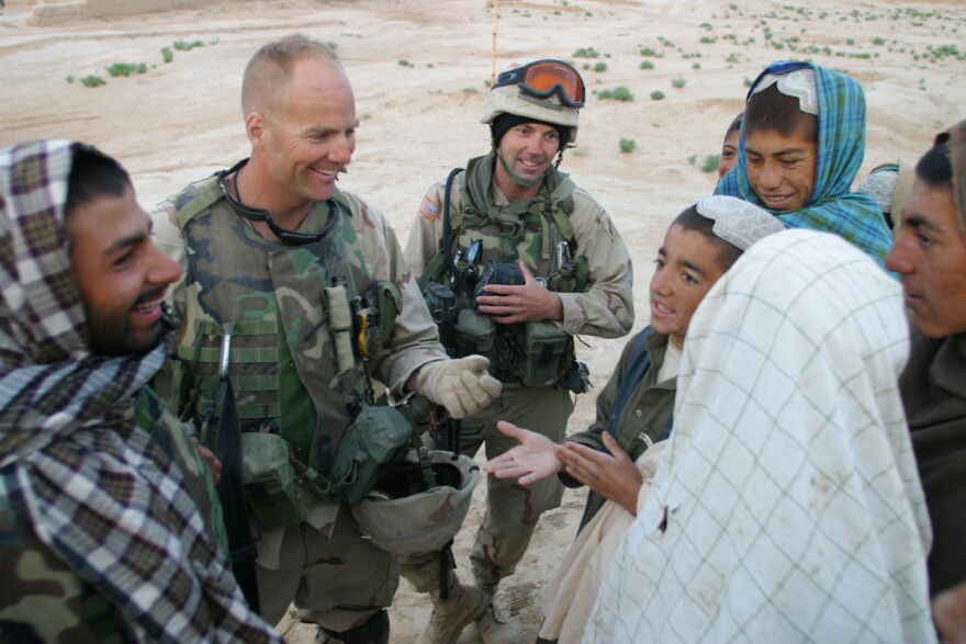 Kit Parker (second from left) and Aaron Chapman (third from left) meet with village elders in the village of Loy Kariz, Afghanistan in 2003.