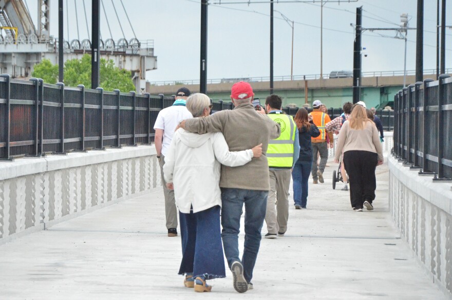 People walk along a bridge.