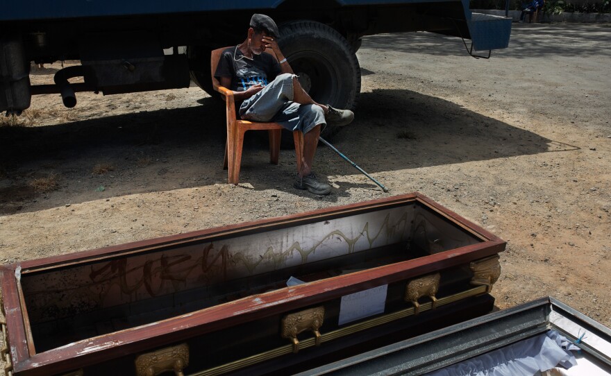 A resident naps in the front yard of the home for senior citizens. The coffin, used at funeral ceremonies but not for burial, is being aired out.