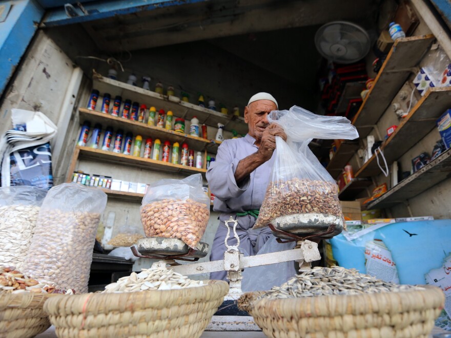 A man weighs goods at a market in Baghdad on Sept. 1. Baghdad's once-bustling markets are facing difficult times as customers stay away, increasingly fearful of bomb attacks.