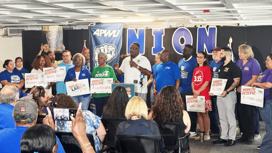 Holding the microphone, South Florida AFL-CIO's President Jeffery Mitchell, surrounded by union leaders in a conference. (Courtesy of South Florida AFL-CIO)