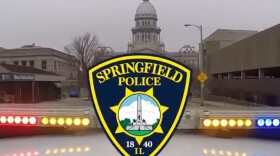 SPD video still with squad car and lights in front of the Illinois Capitol