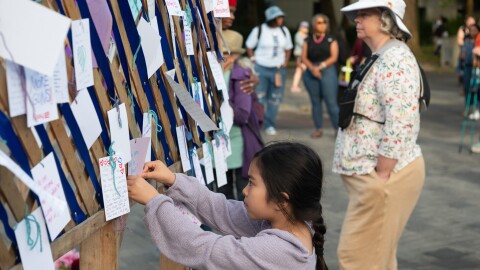 A young girl leaves a message at a silent vigil for the Seattle Center shooting victims.