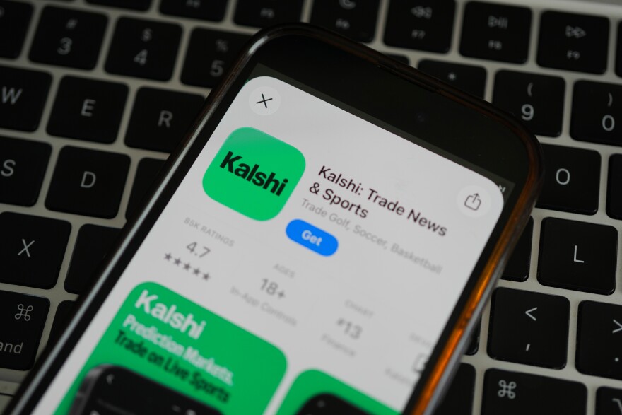 FILE - An ad for the prediction market app Kalshi is displayed on a mobile phone Thursday, April 16, 2026, in Chicago.