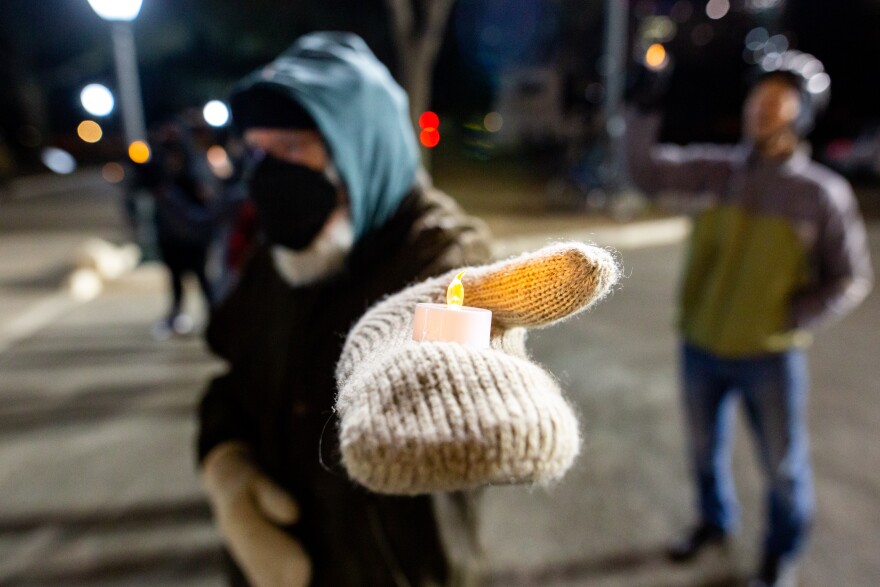 A man holds a candle outside the Texas Capitol on Jan. 6. About 50 people gathered there to mark the anniversary of the attack at the U.S. Capitol. 