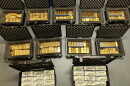 Open boxes full of gold bars and cash.