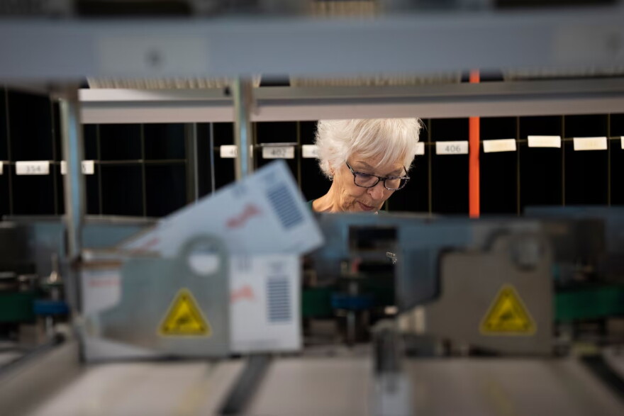 Volunteer Diane Roth collects ballots after they go through a processing machine at the Marion County Clerk's office in Salem, Ore., on May 18, 2026.