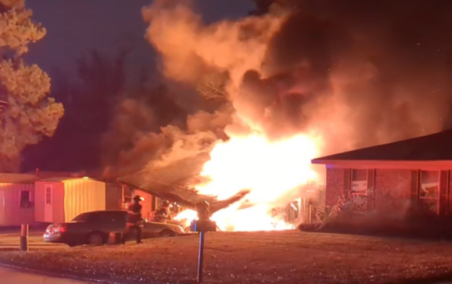 A residential house on fire as first responders attempt to control the fire.