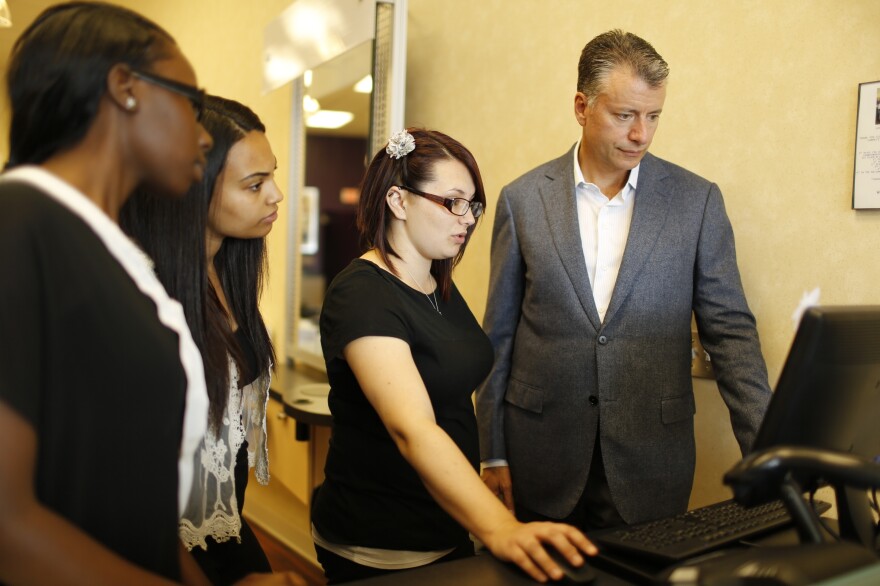 Though the Supercuts imprint is everywhere — from the wallpaper to the reception desk — Gary Robins (right) owns the business and is responsible for the bottom line. Robins and employees at his Havertown, Pa., location look over stats and sales for the week.