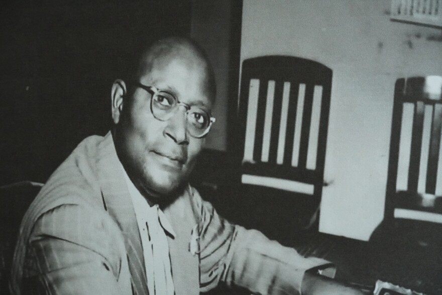 A black and white photo of a man with glasses. 