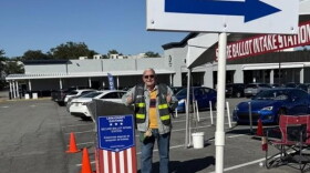 A Leon poll worker smiles and shows thumbs up 