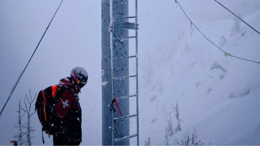 An early-morning patroller prepares to bomb a slope to avoid avalanches at Jackson Hole Mountain Resort in February 2024.