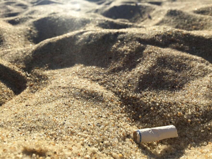 A close-up of a cigarette butt on the sand