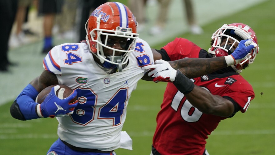 FILE - Florida tight end Kyle Pitts (84) tires to get past Georgia defensive back Lewis Cine (16) after a reception during the first half of an NCAA college football game in Jacksonville, Fla., in this Saturday, Nov. 7, 2020, file photo.