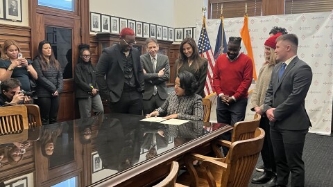 Mayor Applyrs signing an executive order on Jan. 2, with Albany business owners behind her