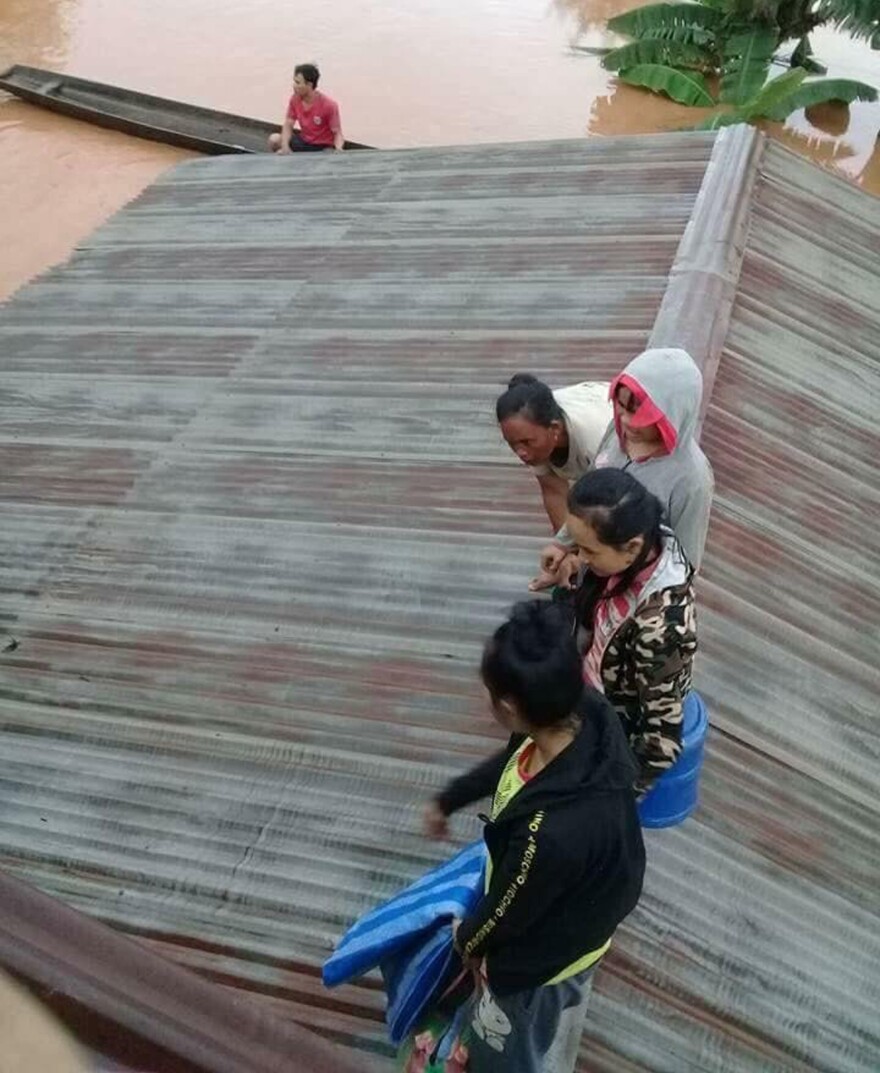 Villagers take refuge on a rooftop above floodwaters from a collapsed dam in southeastern Laos on Tuesday after a newly built hydroelectric dam was breached in southeastern Laos.