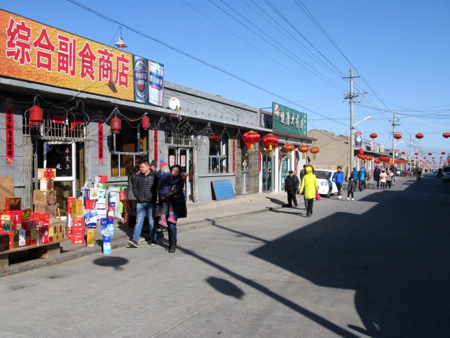 Tourists walk along a main thoroughfare in Nuanquan Town. While Lunar New Year festivities in China's cities have become highly commercialized and must compete with other, more modern diversions, folk customs in China's countryside remain vibrant.