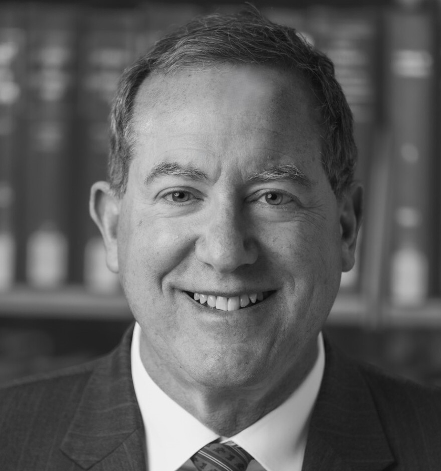 Black and white profile photo of man in suit