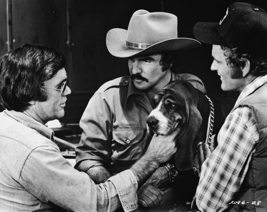 Veteran Hollywood stuntman Hal Needham — who turned director for the 1977 hit <em>Smokey and the Bandit</em> — lines up a shot with Burt Reynolds, Jerry Reed and Happy the dog.