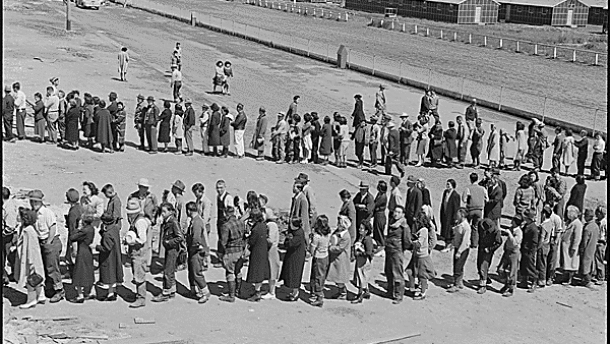 San Bruno, CA, 29 April 1942: This assembly center has been open for two days. Bus-load after bus-load of evacuated persons of Japanese ancestry are arriving on this day after going through the necessary procedures, they are guided to the quarters assigned to them in the barracks. CREDIT: DOROTHEA LANGE/WIKIMEDIA COMMONS