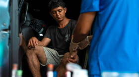 A participant watches as a nurse prepares to draw blood for the CURE study in Usulutan, El Salvador.