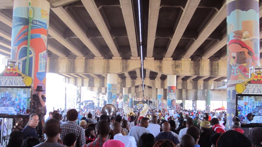 Spectators under the Clariborne Bridge in New Orleans' Treme neighborhood watch To Be Continued Brass Band parade into the judges area on Saturday.