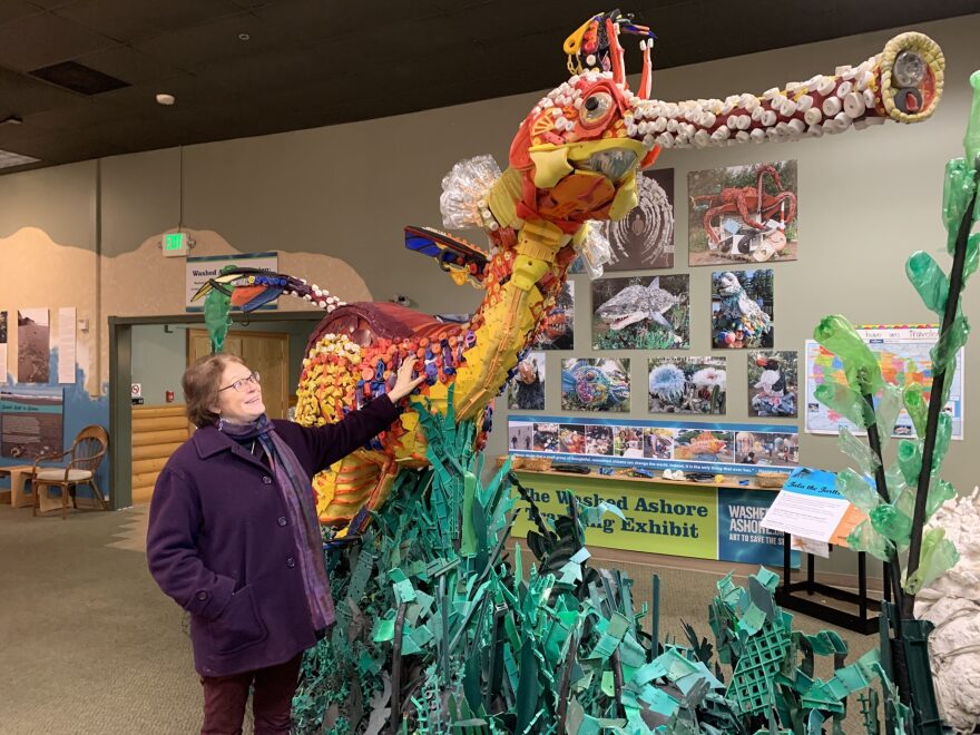 In her gallery in Bandon, Ore., Angela Haseltine Pozzi stands next to an enormous sea dragon sculpted from plastics found on Oregon's beaches that are normally famous for being pristine and wild. Kirk Siegler/NPR
