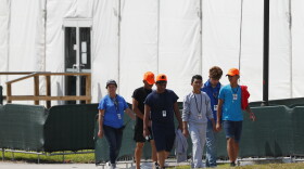 Migrant children walk outside the Homestead Temporary Shelter for Unaccompanied Children in May in Homestead, Fla.