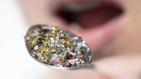 A close-up of a spoon with small gold and silver particles